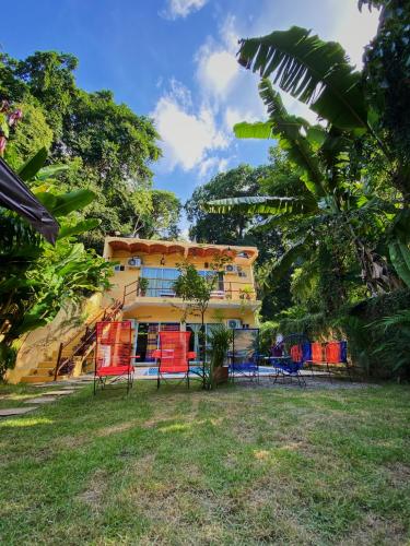 サユリタにあるHabitacion privada con pisicina compartidaの赤い椅子が前に並ぶ黄色い建物