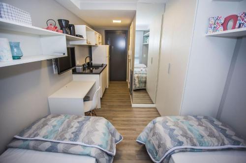 a small room with two beds and a kitchen at Studio com 2 Camas de Solteiro - ALL0703 in Curitiba