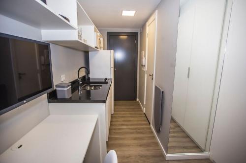 a small kitchen with a sink and a refrigerator at Studio com 2 Camas de Solteiro - ALL0703 in Curitiba