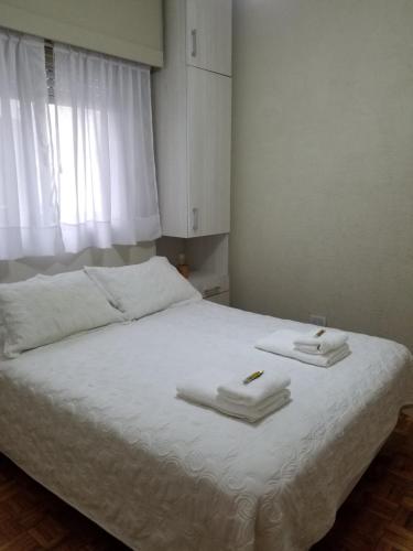 um quarto com uma cama com toalhas em SUH Apartment em Buenos Aires