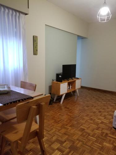 uma sala de estar com uma mesa e uma televisão em SUH Apartment em Buenos Aires