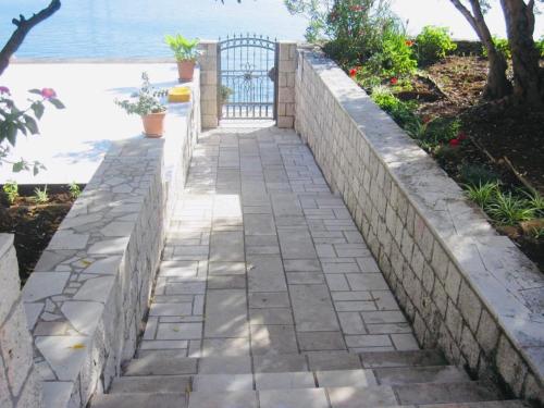 a retaining wall with a stone walkway next to the water at Holiday Home Adriatic in Lumbarda