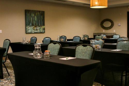 une salle de conférence avec des tables, des chaises et un tableau dans l'établissement Holiday Inn & Suites Denver Tech Center-Centennial, an IHG Hotel, à Centennial