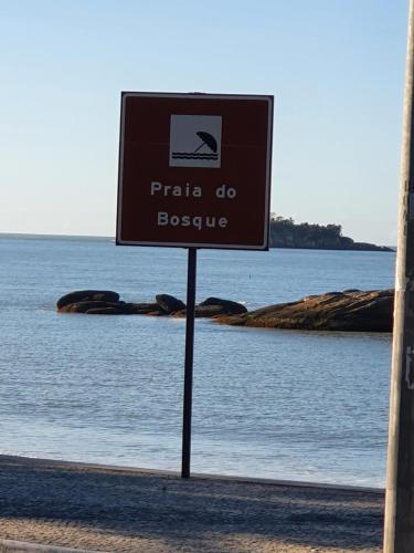 a sign in front of a body of water at Pousada do Bosque in Rio das Ostras