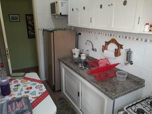 uma cozinha com um lavatório e uma bancada em Apartamento na enseada 50 metros da praia no Guarujá