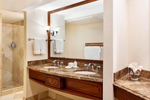 a bathroom with two sinks and a large mirror at The Tides Inn in West Irvington