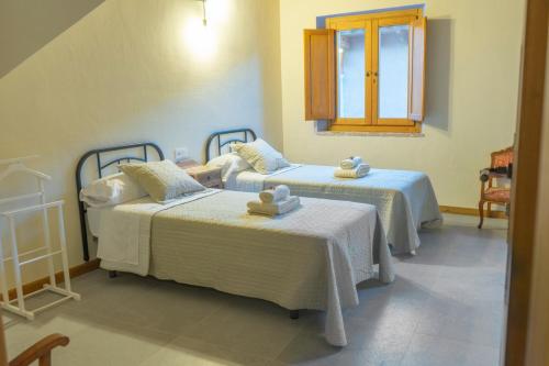 a room with two beds and a window at Casa Rural Bonal in La Mata de los Olmos