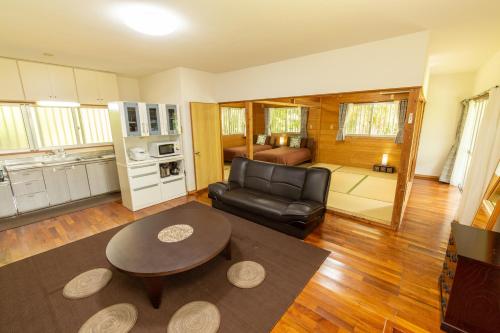 a living room with a leather couch and a table at Villa Itona ishigakijima in Ishigaki Island