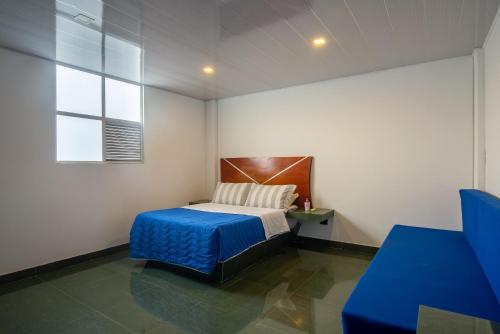a small bedroom with a bed and a window at Terrazas De Baltimoores in San Joaquín