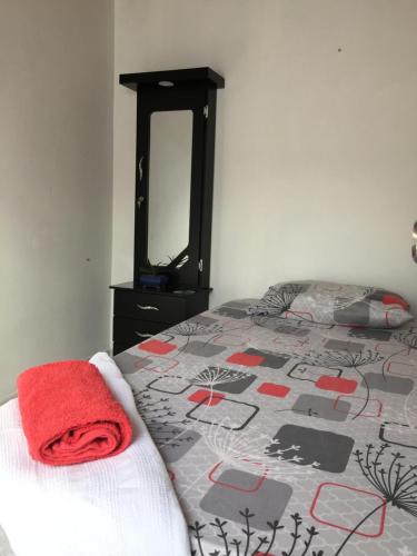 Un dormitorio con una cama con una toalla roja. en Habitación privada en casa de familia cerca del CC VIVA Envigado, en Itagüí