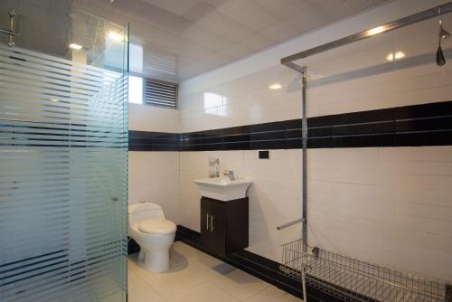 a bathroom with a toilet and a glass shower at Terrazas De Baltimoores in San Joaquín