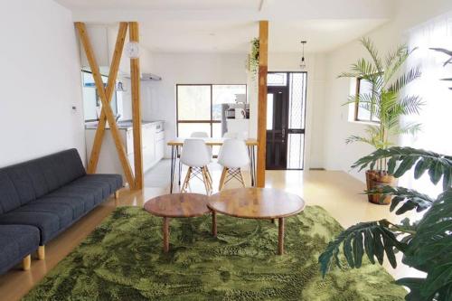 a living room with a couch and a table at SURF BLUE 九十九里 in Ichinomiya