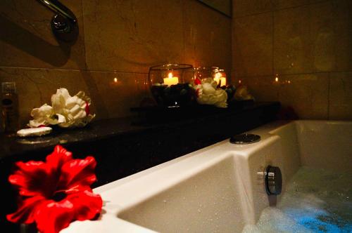 a bathroom with a bath tub with candles on a counter at Hotel Casa Mahanaim Colferias, Bogotá in Bogotá