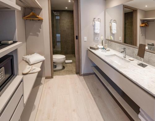 a bathroom with two sinks and a toilet at Hotel York Luxury Suites Medellin by Preferred in Medellín