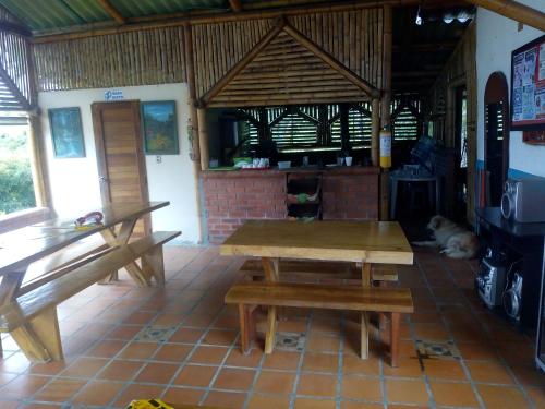 a table and benches in a room with a dog at Hotel Campestre Alto Bonito del Quindío in El Cuzco