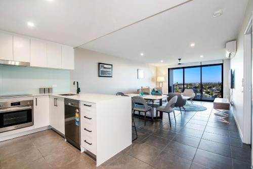 a kitchen and dining room with a table and chairs at Hedge Apartments by CLLIX in Buddina