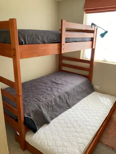 a bedroom with two bunk beds and a window at Departamento Laguna Bahia in Algarrobo