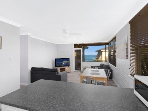 a kitchen and living room with a view of the ocean at Golden Sands Apartment 10 in The Entrance