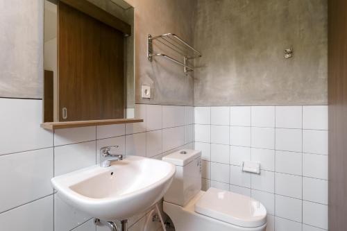 a white bathroom with a sink and a toilet at RedDoorz Syariah near Rumah Sakit Medika Dramaga in Bogor