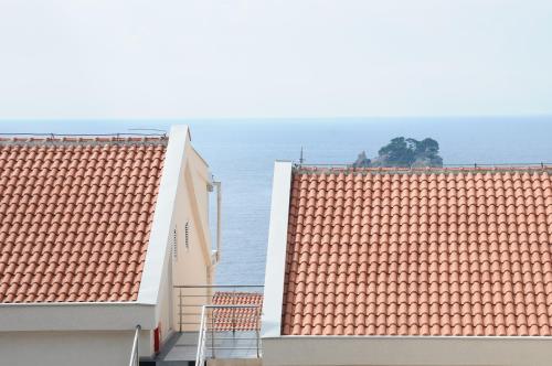 two roofs of two buildings with the ocean in the background at Vila Apartments Lidija in Petrovac na Moru