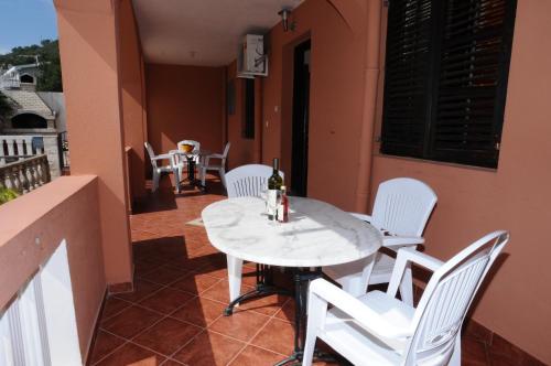 a table and chairs on a balcony with a bottle of wine at Vila Apartments Lidija in Petrovac na Moru