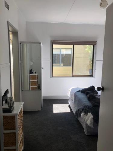 a bedroom with a bed and a window at Koonwarra Holiday Park in Lakes Entrance