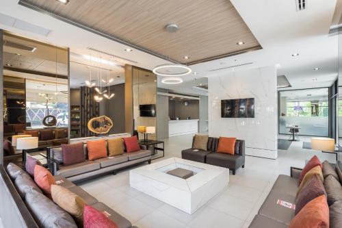 a living room with couches and a table at Altera Hotel and Residence by At Mind in Pattaya Central