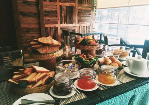 a table topped with baskets of bread and other food at Ayurvie Weligama - Ayurvedic Retreat by Thema Collection in Weligama