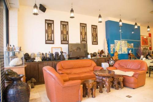 a living room with two orange chairs and a table at Golden Ocean Azure Hotel in Kenting