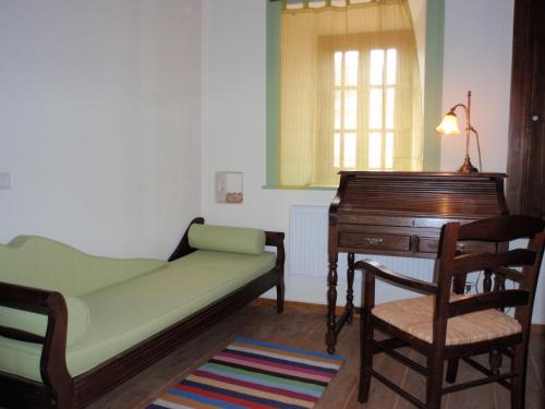 a bedroom with a bed and a desk and a piano at Villa Notia in Skala Eresou