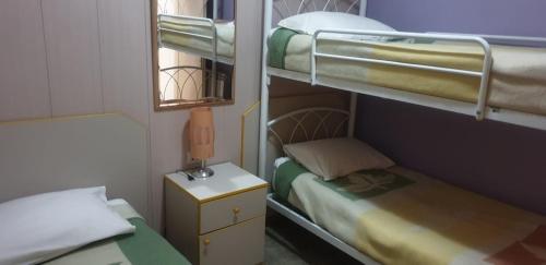 a small room with two bunk beds and a lamp at Stone Chalets in Fārayyā