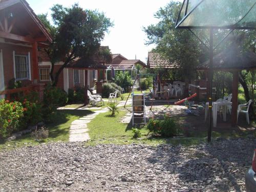 a backyard with a playground with chairs and tables at Complejo Sagrado Corazón in Merlo