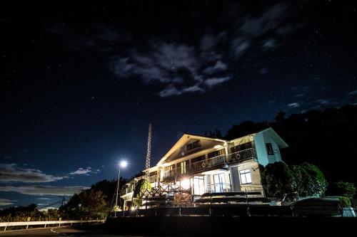 a house is lit up at night at Pension KUROSHIOMARU in Setouchi