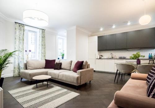 a living room with a couch and a kitchen at Sienna 41 Boutique Warsaw Apartments in Warsaw