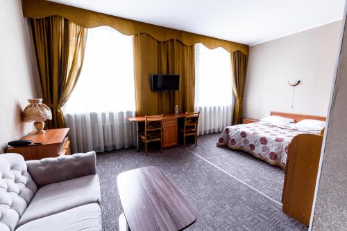 Pokój hotelowy z łóżkiem i biurkiem w obiekcie Hotel Central w mieście Kursk