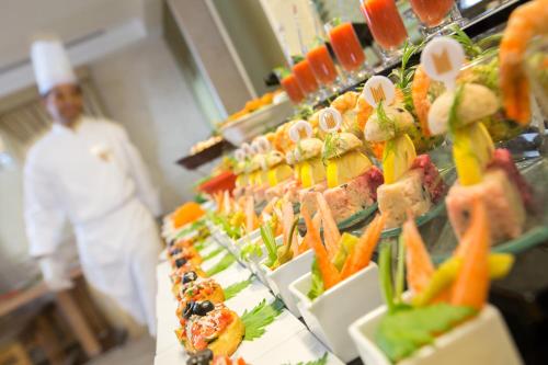 a chef standing in front of a buffet of food at Millennium Kurdistan Hotel & Spa in As Sulaymānīyah