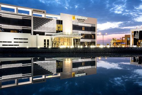 a building with its reflection in a body of water at Millennium Kurdistan Hotel & Spa in As Sulaymānīyah