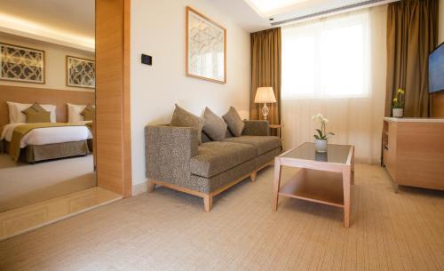 a hotel room with a couch and a bed at Millennium Kurdistan Hotel & Spa in As Sulaymānīyah