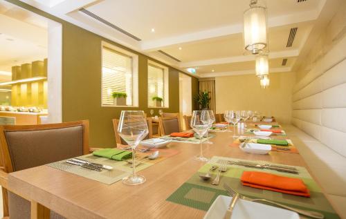 a dining room with a long table with wine glasses at Millennium Kurdistan Hotel & Spa in As Sulaymānīyah