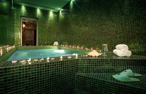 a green tiled bathroom with a swimming pool with a hat at Millennium Kurdistan Hotel & Spa in As Sulaymānīyah