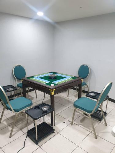 a ping pong table with four chairs in a room at Chuan Fu Hotel in Fengyuan