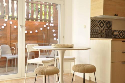 a kitchen with a table and stools in a room at Aux cigognes de Blotzheim in Blotzheim