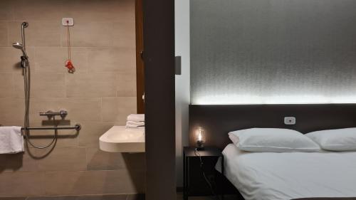 y baño con cama, lavabo y ducha. en Hotel Drie Eiken en Edegem