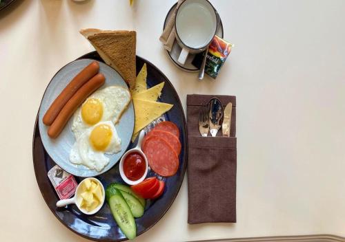 ein Frühstücksteller mit Eierwurst und Tomaten in der Unterkunft Boutique Hotel Kaspi in Temirtaū