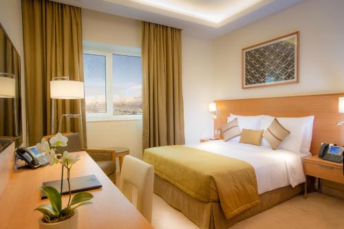 ein Hotelzimmer mit einem Bett und einem Schreibtisch in der Unterkunft Millennium Kurdistan Hotel & Spa in Sulaimaniyya