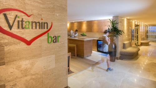 a man walking in front of a bar in a building at Millennium Kurdistan Hotel & Spa in As Sulaymānīyah