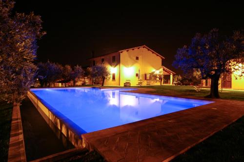 a swimming pool at night with a house in the background at Agriturismo Le Vigne in Foligno