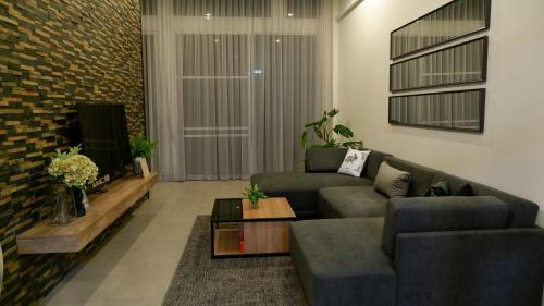 a living room with a couch and a tv at The Midst by The M - Nakhon Nayok TMD4 in Ban Som Phung Haeng (1)