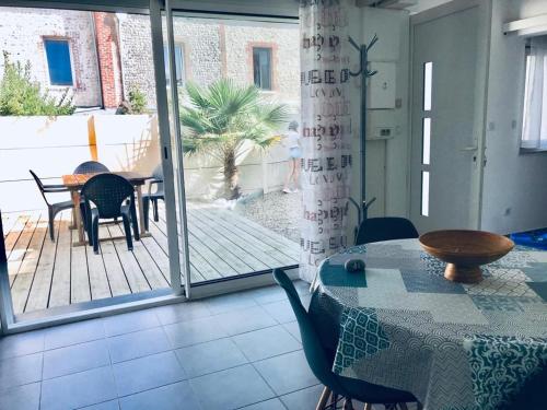 Cette chambre comprend une table, des chaises et une terrasse. dans l'établissement L'Ilot, à Fécamp