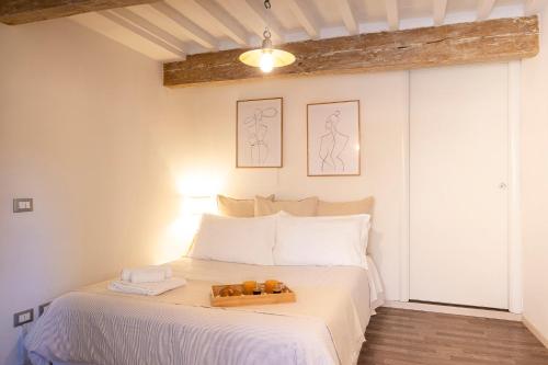 ORANGE Tuscany Flat في سان مينياتو: غرفة نوم مع سرير عليه صينية برتقال